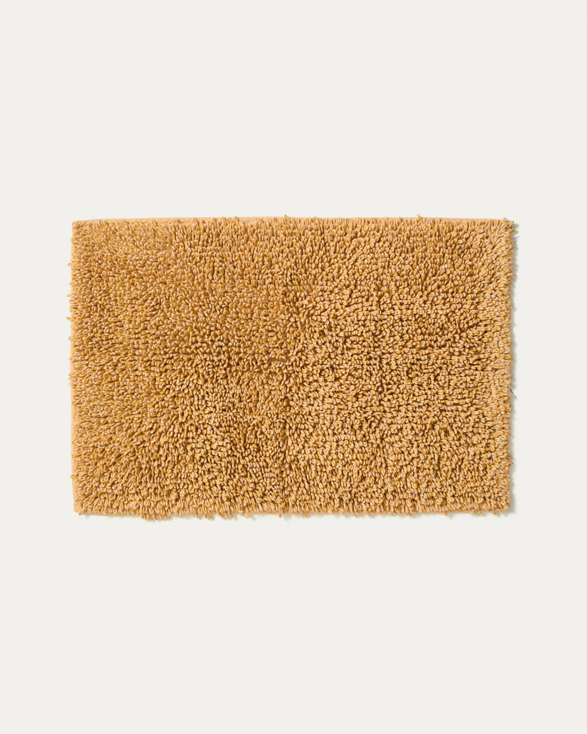 Senfgelbe Badezimmermatte Aroia von Kave Home mit Bouclé-Melange-Struktur in rechteckiger Form, Grösse 50 x 70 cm, auf Boden liegend.
