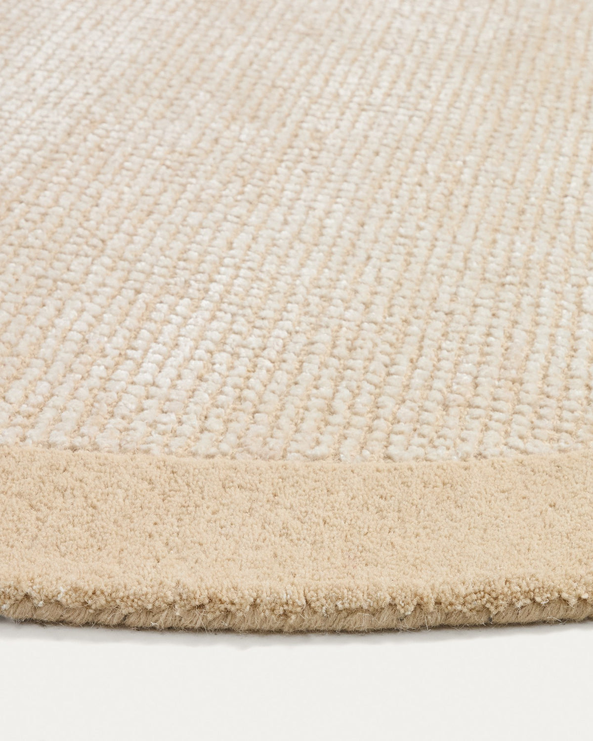 Beige Teppich Ivena von Kave Home mit Wollrahmen und Viskose-Innenseite, handgewebt mit sichtbaren Naturfaser-Unregelmässigkeiten.