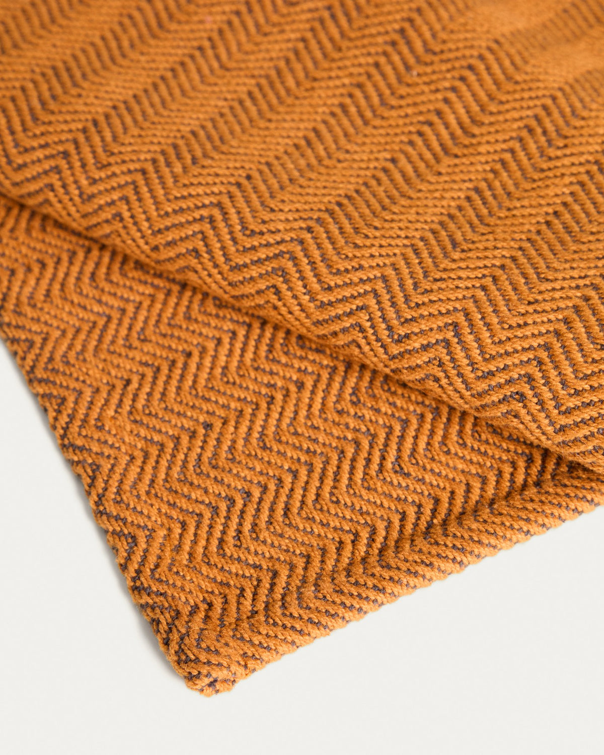 Zwei rechteckige Tischsets aus Baumwolle mit Jacquard-Muster in Senfgelb, Grösse 35 x 50 cm, auf einem Tisch platziert.