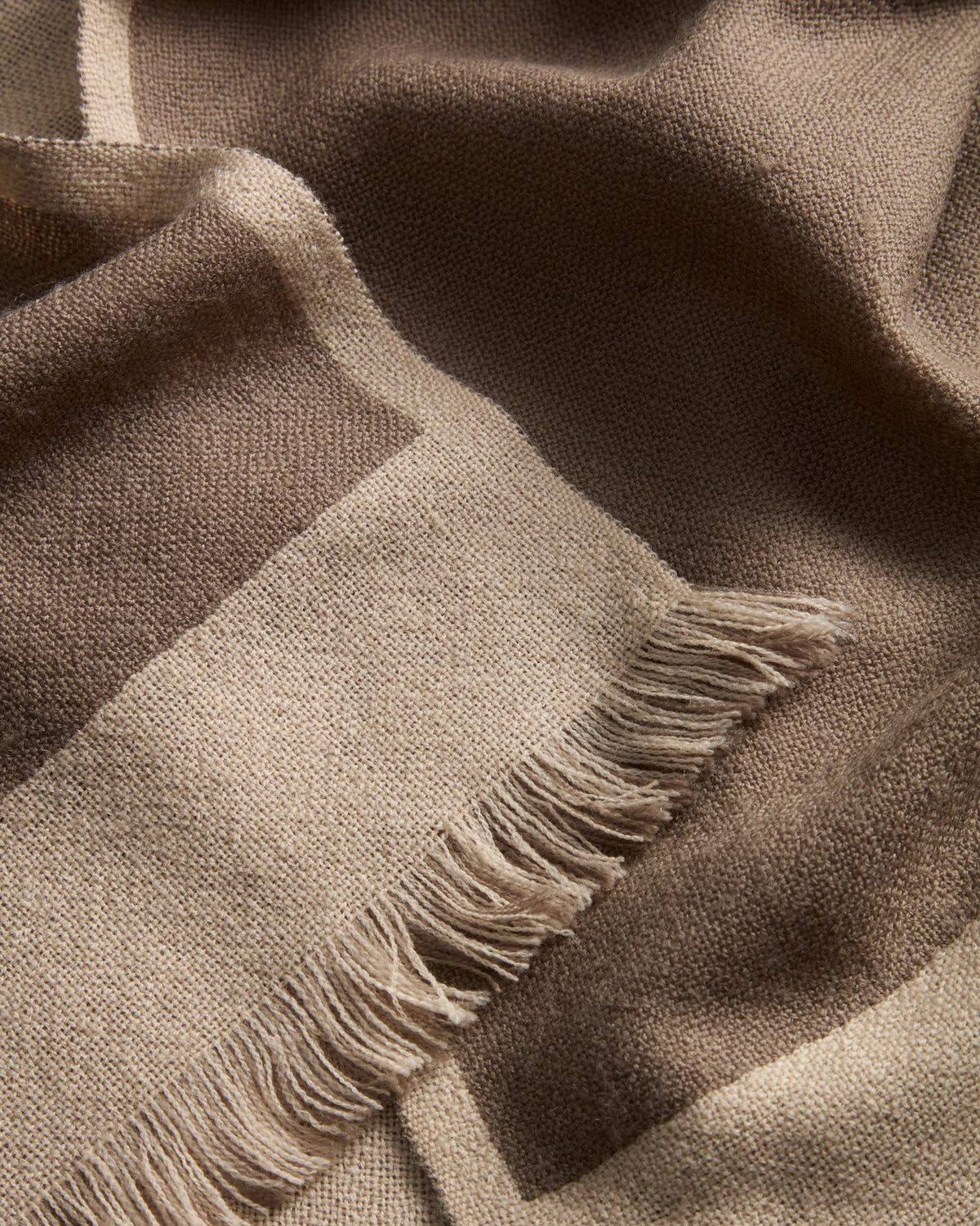 Wendbare Wolldecke Orlet in Grau und Beige aus 100% Wolle, rechteckige Form mit Fransen an den Rändern, Grösse 130x170 cm.