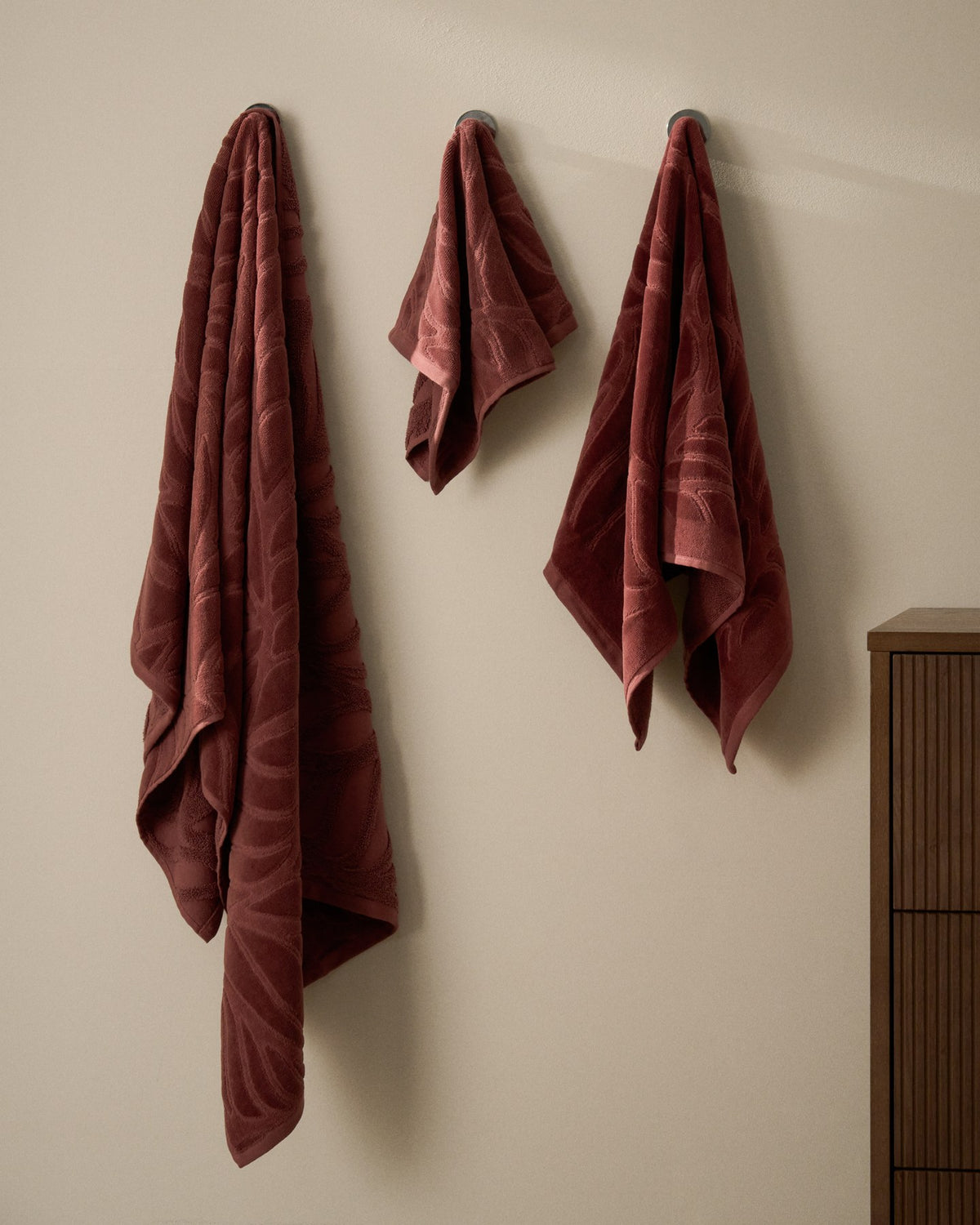 Weinrotes Badetuch aus Baumwolle mit Jacquard-Muster und samtiger Oberfläche, Grösse 70 x 140 cm, gefaltet dargestellt.