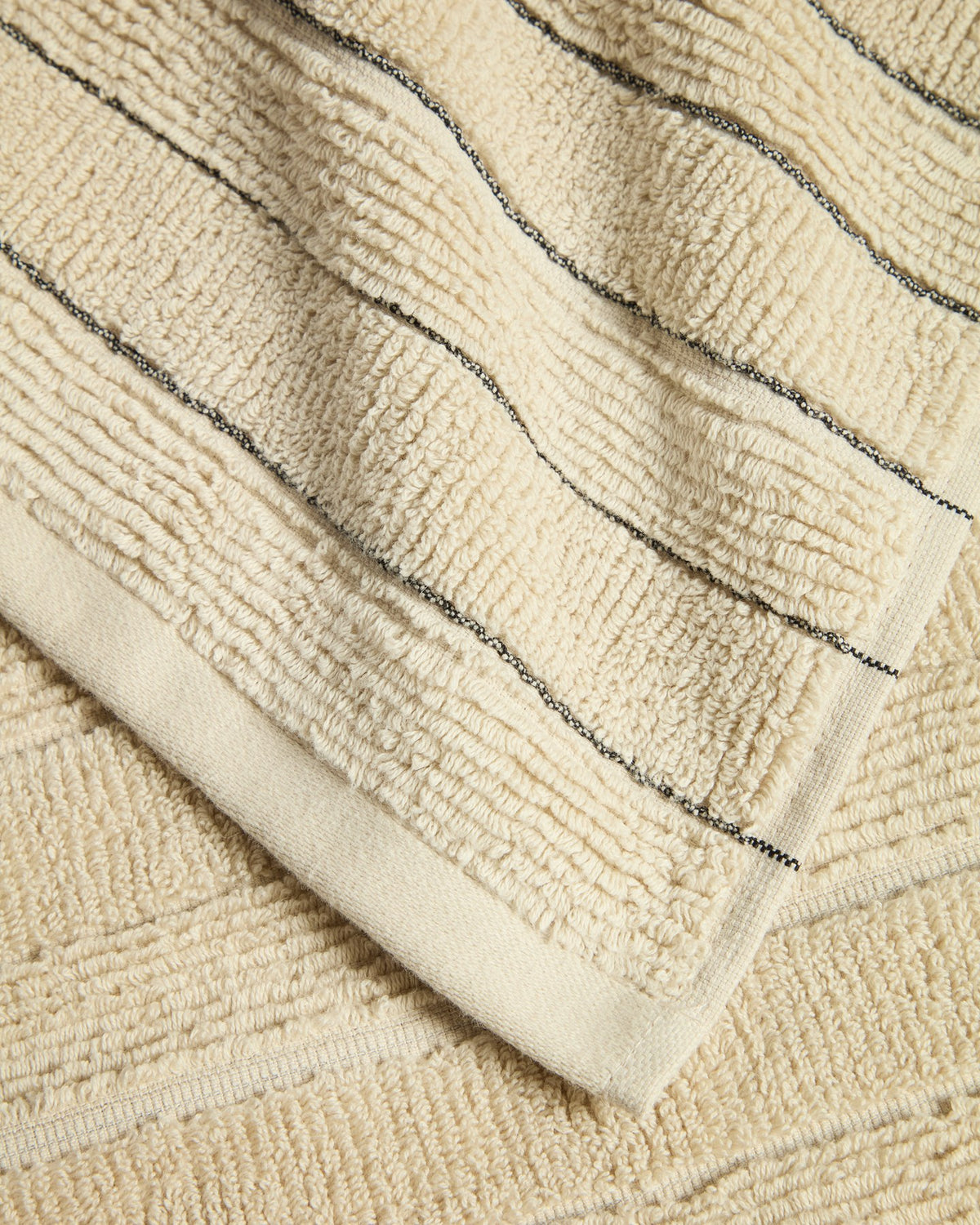 Beiges Badetuch aus Jacquard-Baumwolle mit Streifenmuster, Format 70 x 140 cm, gefaltet auf hellem Untergrund fotografiert.