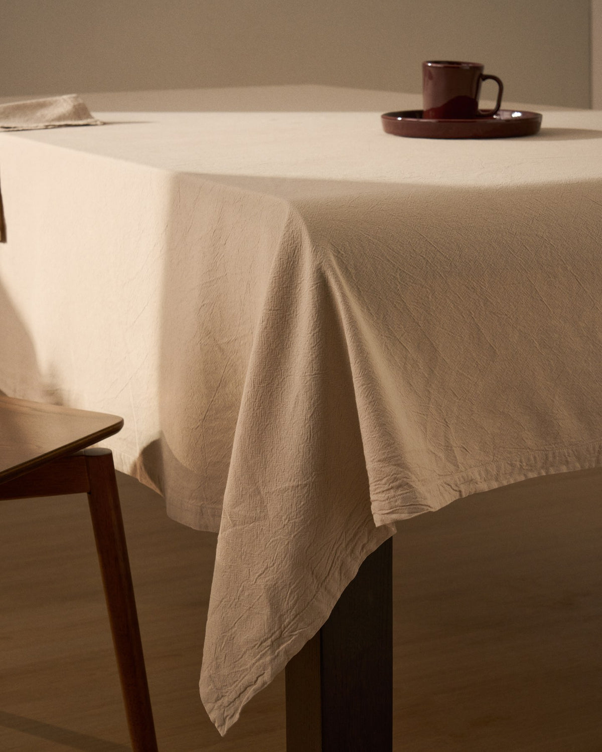 Steinfarbene Tischdecke Levara aus Baumwolle mit Washed-Finish, rechteckige Form, ausgebreitet auf einem Esstisch, Grösse 170 x 250 cm.
