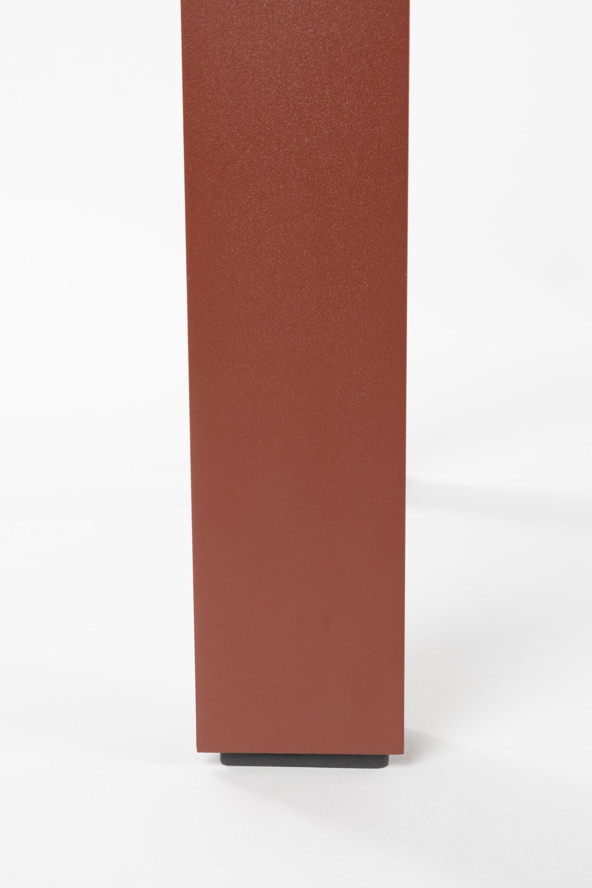 Roter Gartentisch Vondel von Zuiver aus pulverbeschichtetem Aluminium mit rechteckiger Tischplatte und schlanken Beinen im Freien.