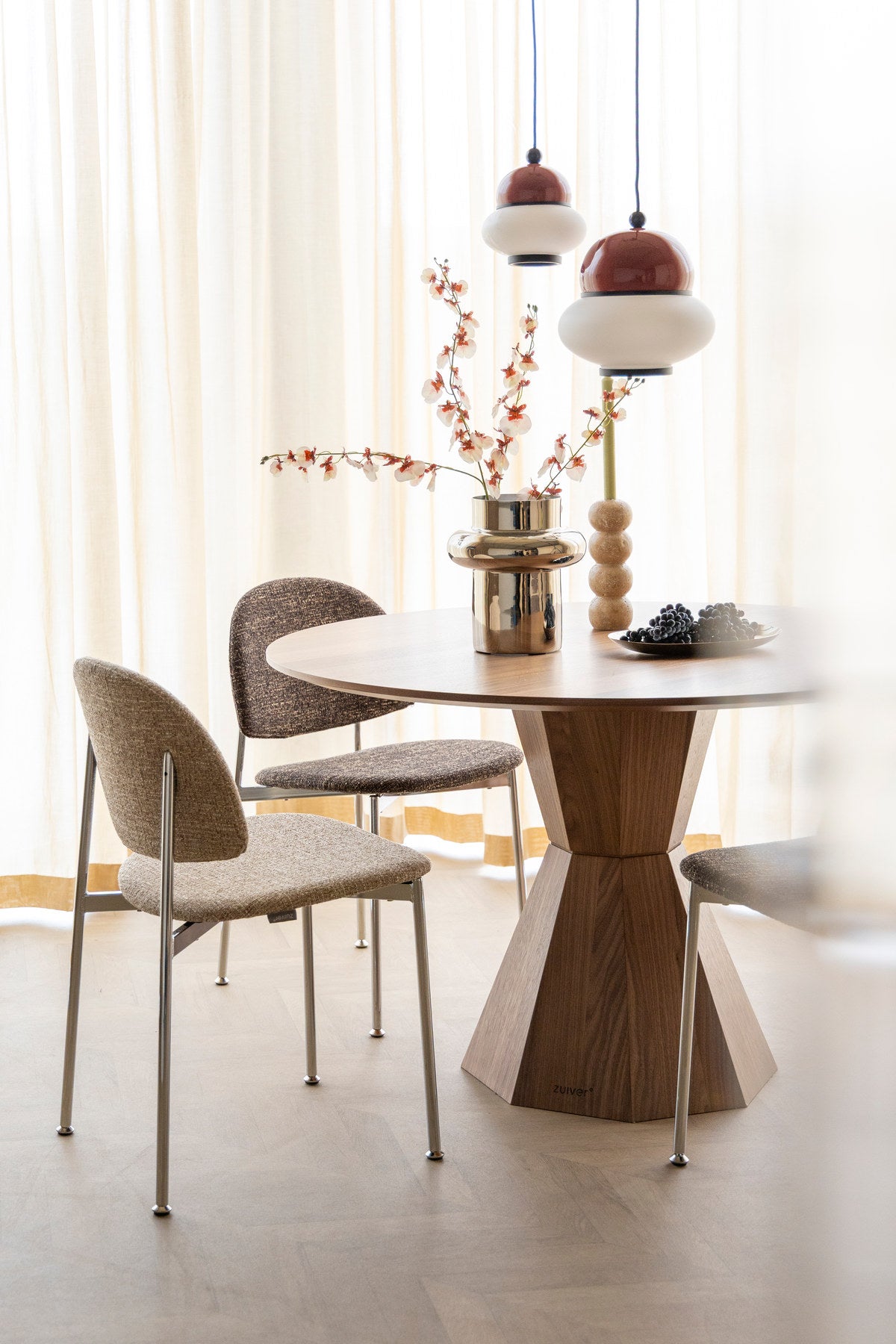 Stuhl mit rundem Rückenlehnendesign, beigem Polyesterbezug und silberfarbenem Gestell, freistehend fotografiert, Zuiver Sunrise Chair.