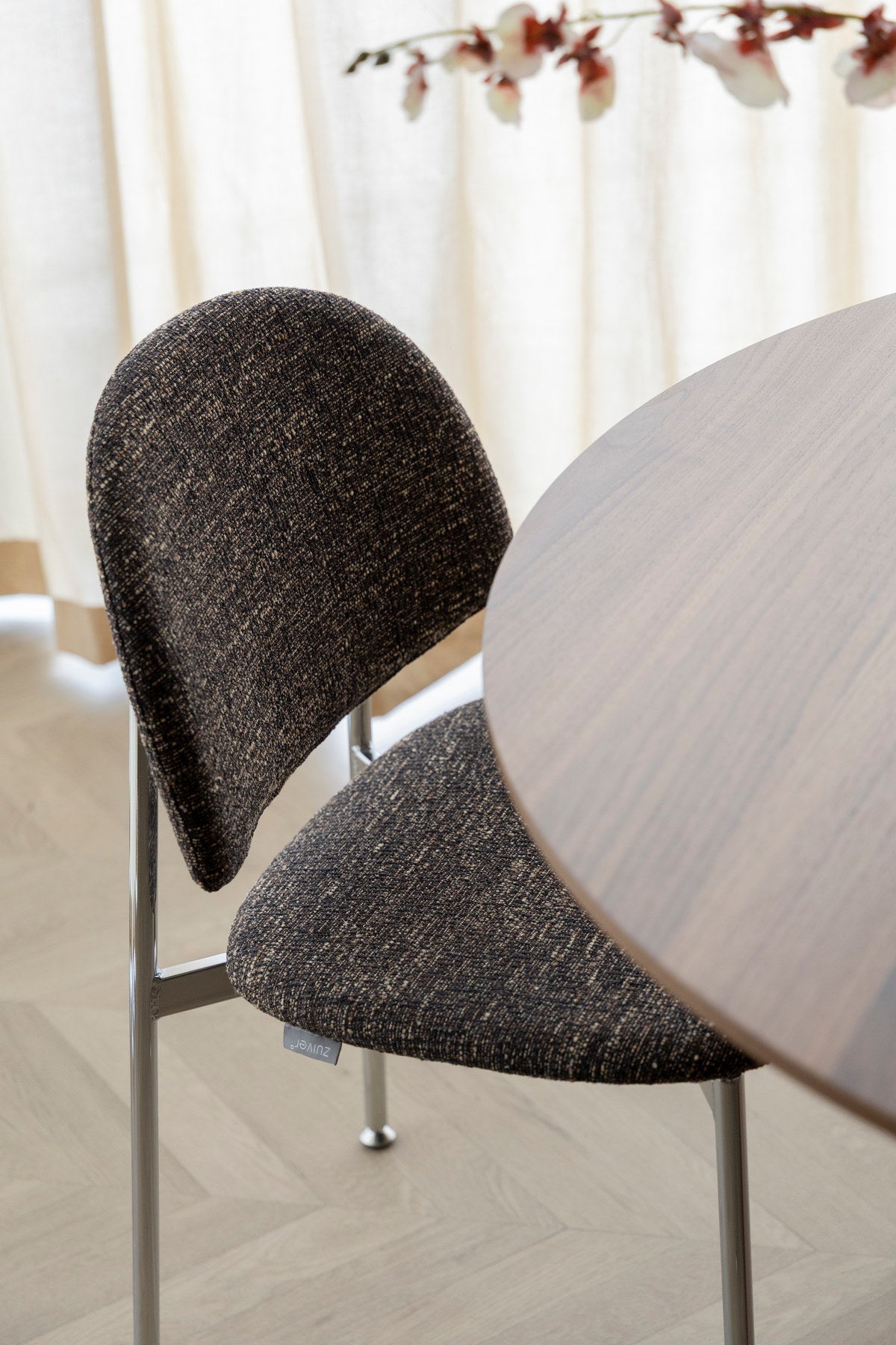 Stuhl Chair Sunrise Silver/Brown von Zuiver mit rundlicher Rückenlehne, braunem meliertem Polyesterbezug und silbernem Gestell, freigestellt.