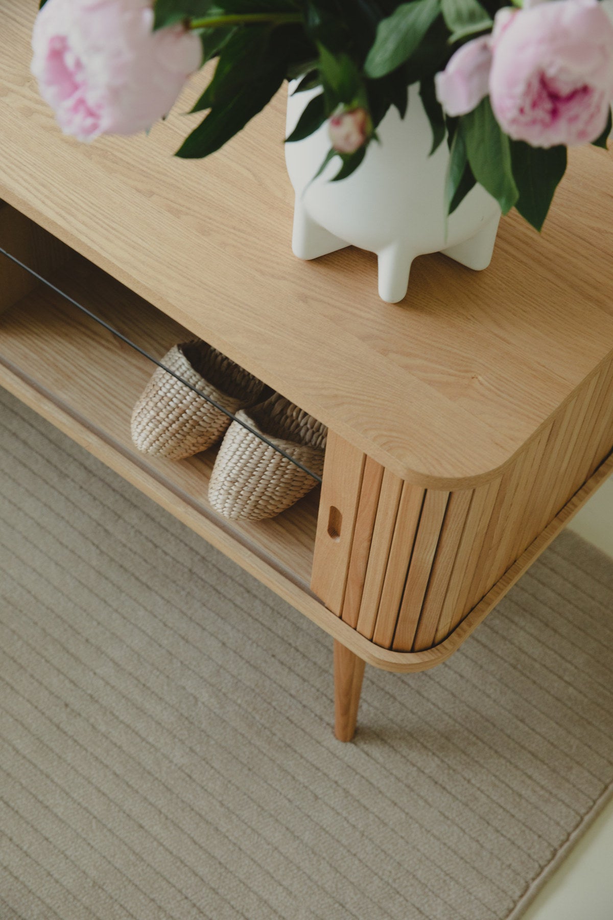 Sideboard Barbier von Zuiver in Natur mit Schiebetüren aus vertikalen Eschenholz-Lamellen, Beinen aus massivem Eschenholz und Regal aus gehärtetem Glas.