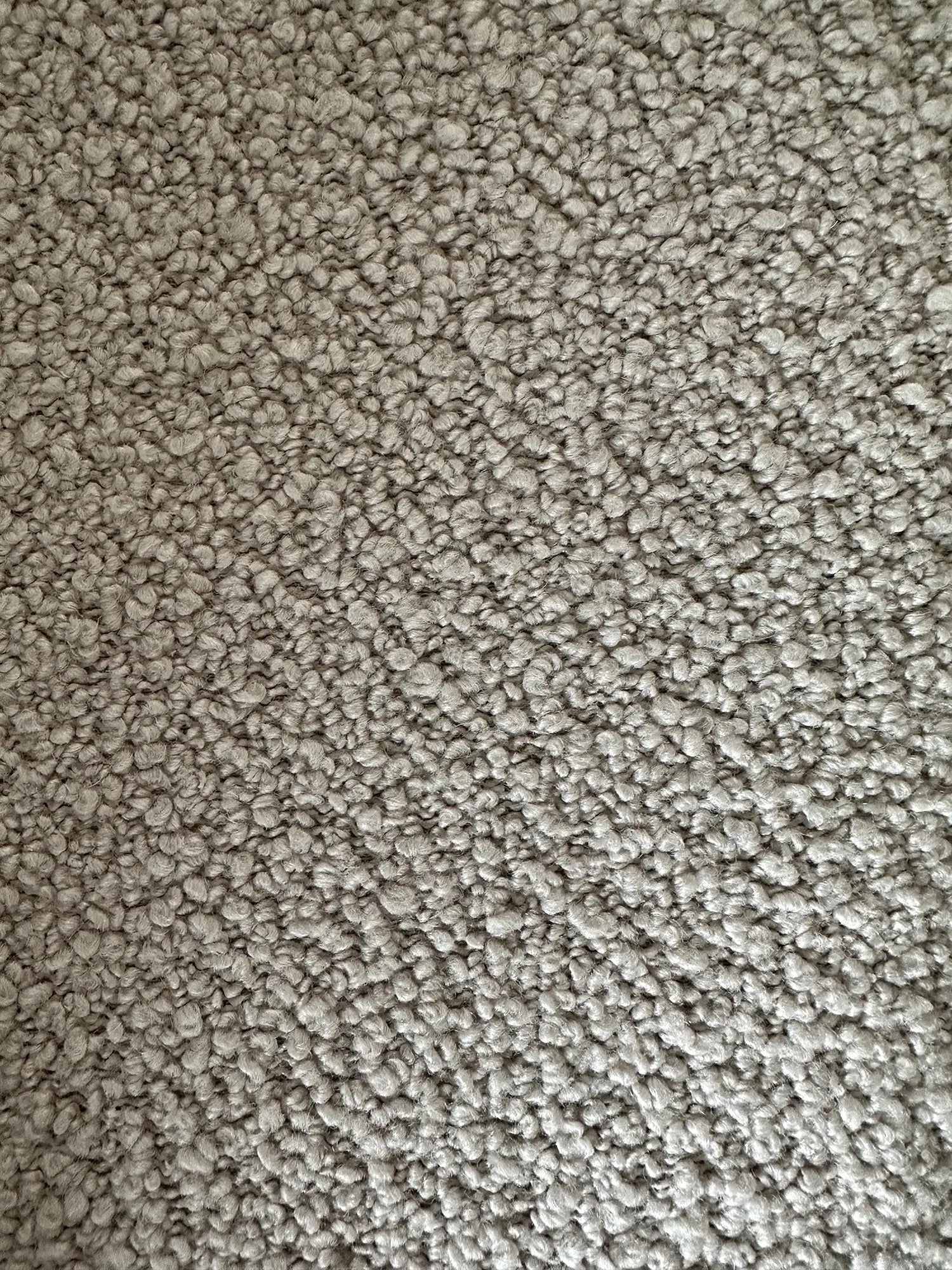 Eleganter Hyg Lounge Drehsessel mit hoher Rückenlehne, gepolstert mit strukturiertem Bouclé-Stoff, skandinavischer Stil, drehbar und mit Kippfunktion, präsentiert als stilvolles Ausstellungsstück in heller Farbgebung.